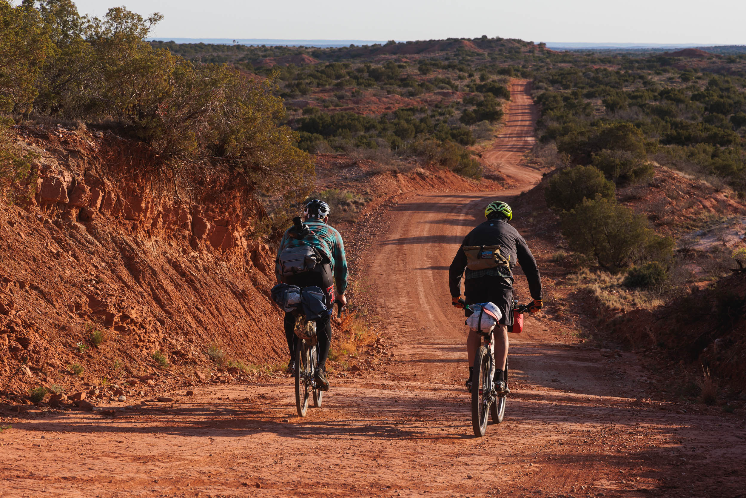 Shows two cyclists on a red desert track, showcasing Litebike lightweight bike parts including cassettes, stems, seatpost and handlebars